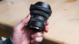 Sigma 10-18mm f/2.8 DC DN lens in the hand showing its small size
