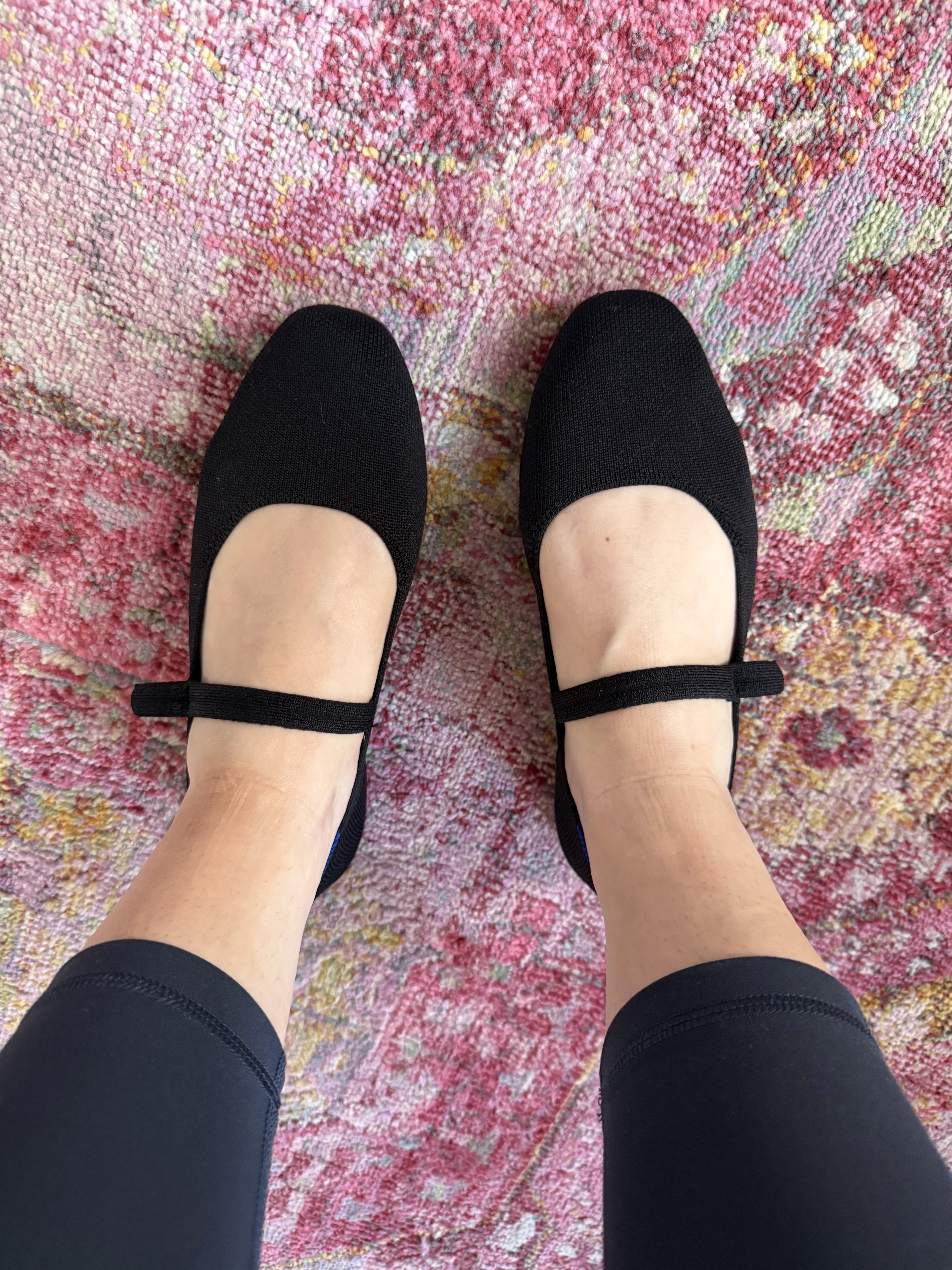 black rothys mary jane flats on pink patterned rug