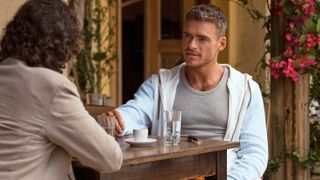 Joseph Gordon-Levitt (L) sits across from Richard Madden at a table in Prime Video original movie "Killer Heat"