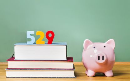 529 college savings plan theme with textbooks and piggy bank and green chalkboard background