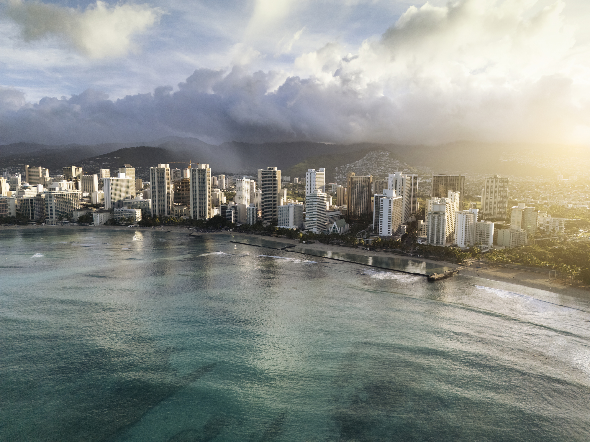 The city of Honolulu seen from above, with a cityscape and beach.