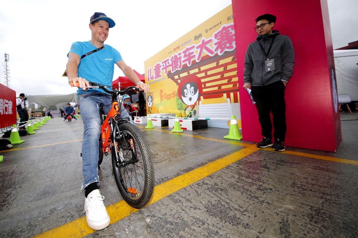Jakob Fuglsang races with some local children