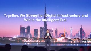 A Huawei representative stood in front of a screen showing the Dubai skyline and bearing the text "Together, We Strengthen Digital Infrastructure and Win in the Intelligent Era!" at the Gitex Global event in Dubai.