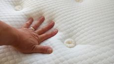 Hand pressing down on Silentnight Geltex Pocket 3000 mattress