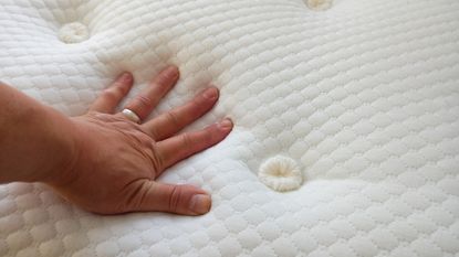Hand pressing down on Silentnight Geltex Pocket 3000 mattress