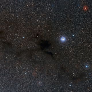 Lupus 4 — a dark, spider-shaped cloud of gas — takes center stage in this wide view of the cloud located 400 light-years from Earth. Photo released Sept. 3, 2014.