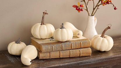 Display of white pumpkins on a book