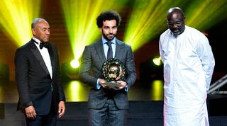 Liverpool's Mohamed Salah receives the African Footballer of the Year award alongside former Ballon d'Or winner George Weah in 2019.