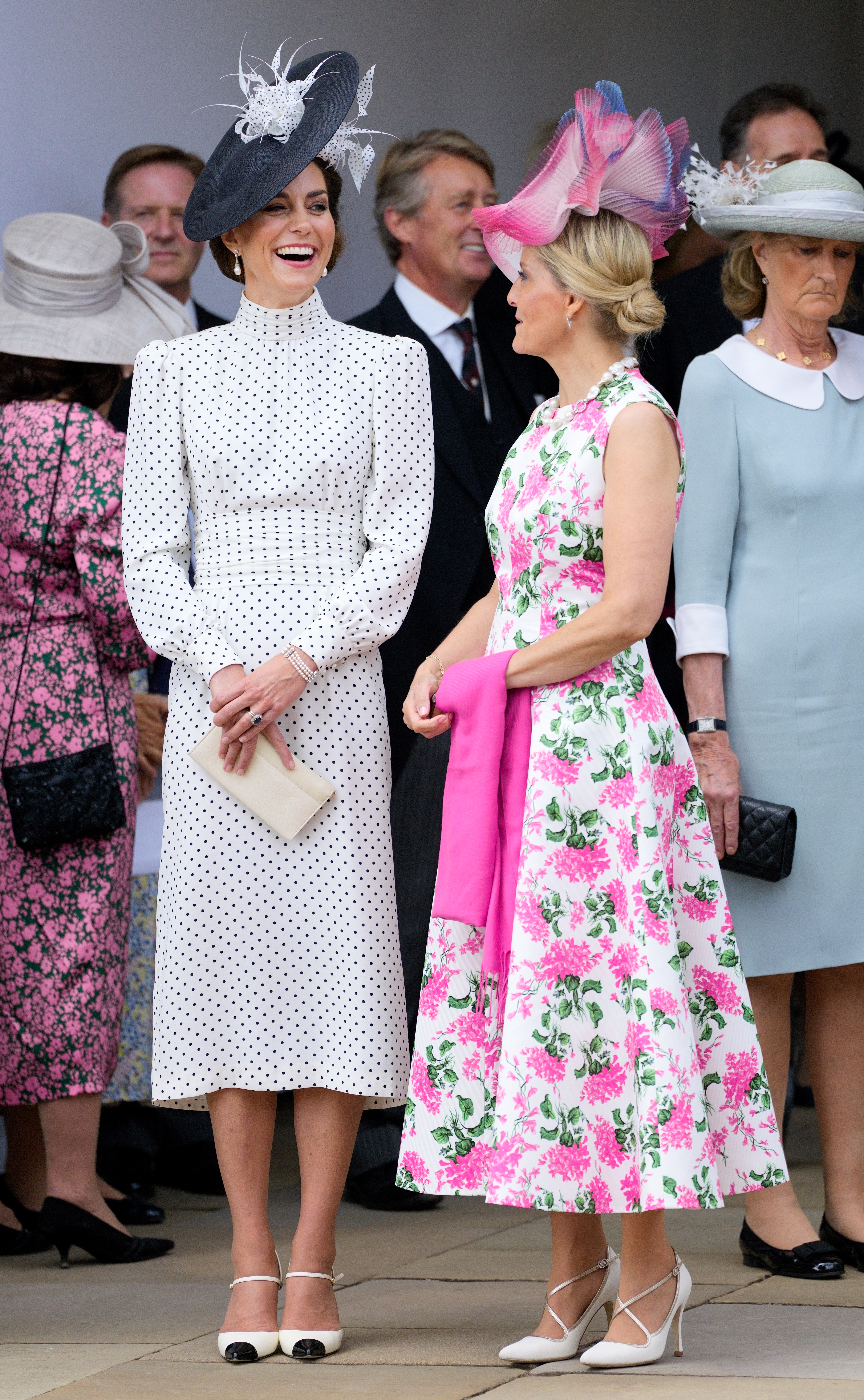 Kate Middleton in a white dotted dress and Duchess Sophie in a pink floral dress smiling on Garter Day 2023