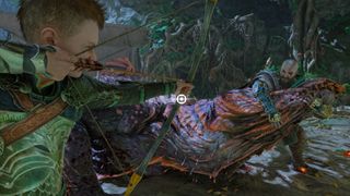 Atreus shoots a bow and arrow at crocodile as Kratos holds it in God of War Ragnarok