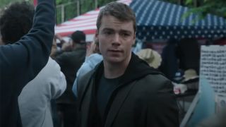 Gabriel Basso standing in a crowd playing Peter Sutherland in The Night Agent Season 2.