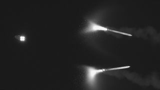 The small Orion capsule faces away on the left and two nearly-identical rocket boosters are on the right. 