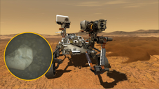 An illustration of Mars' Perseverance rover with a circular boxout showing a gray crystalline shape over a dark background