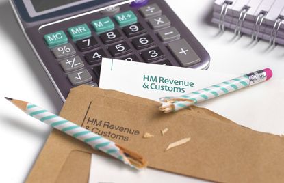Calculator, tax bill and broken pencil on a white table