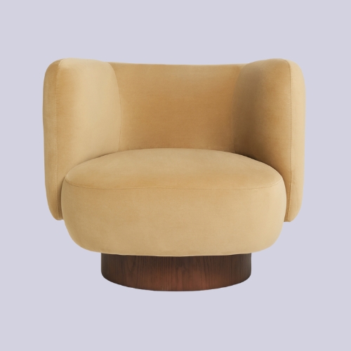 Image of a caramel, velvet accent chair on a lilac background