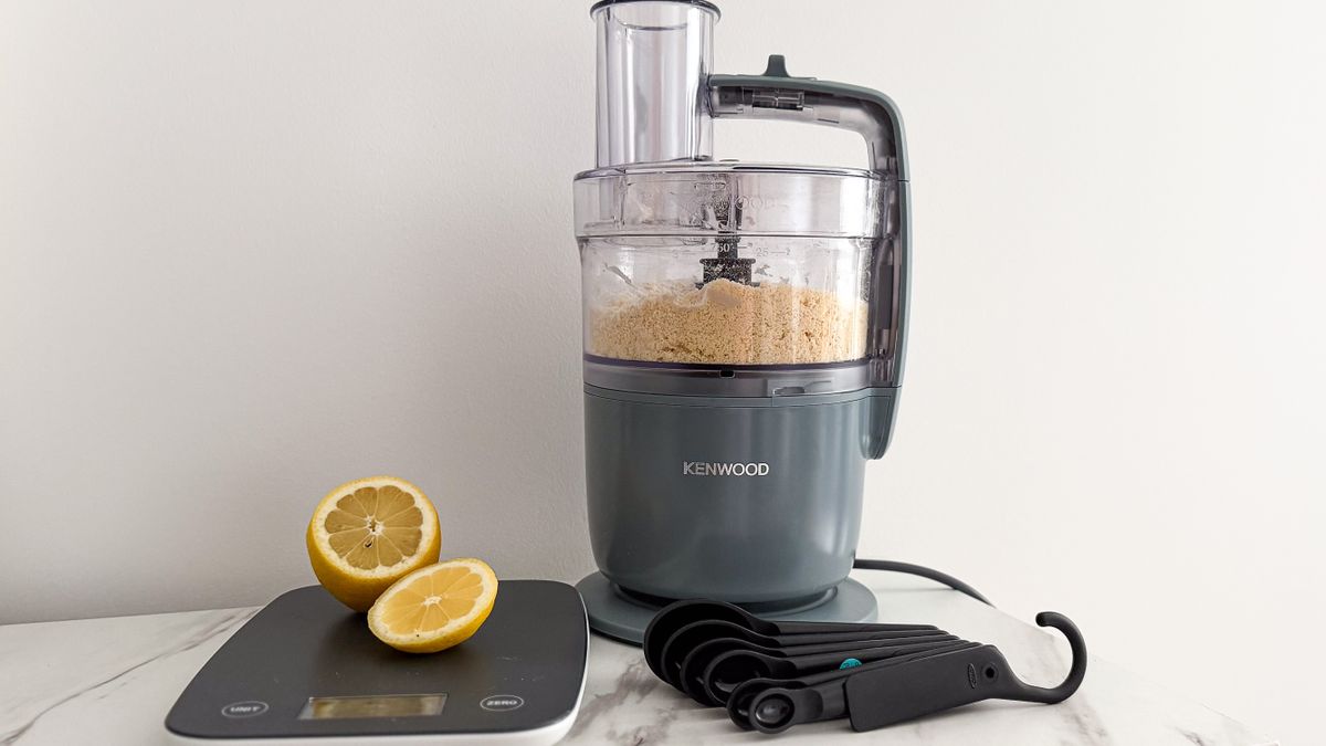 Kenwood MultiPro Go food processor on a table beside kitchen scales, lemon pieces and measuring spoons