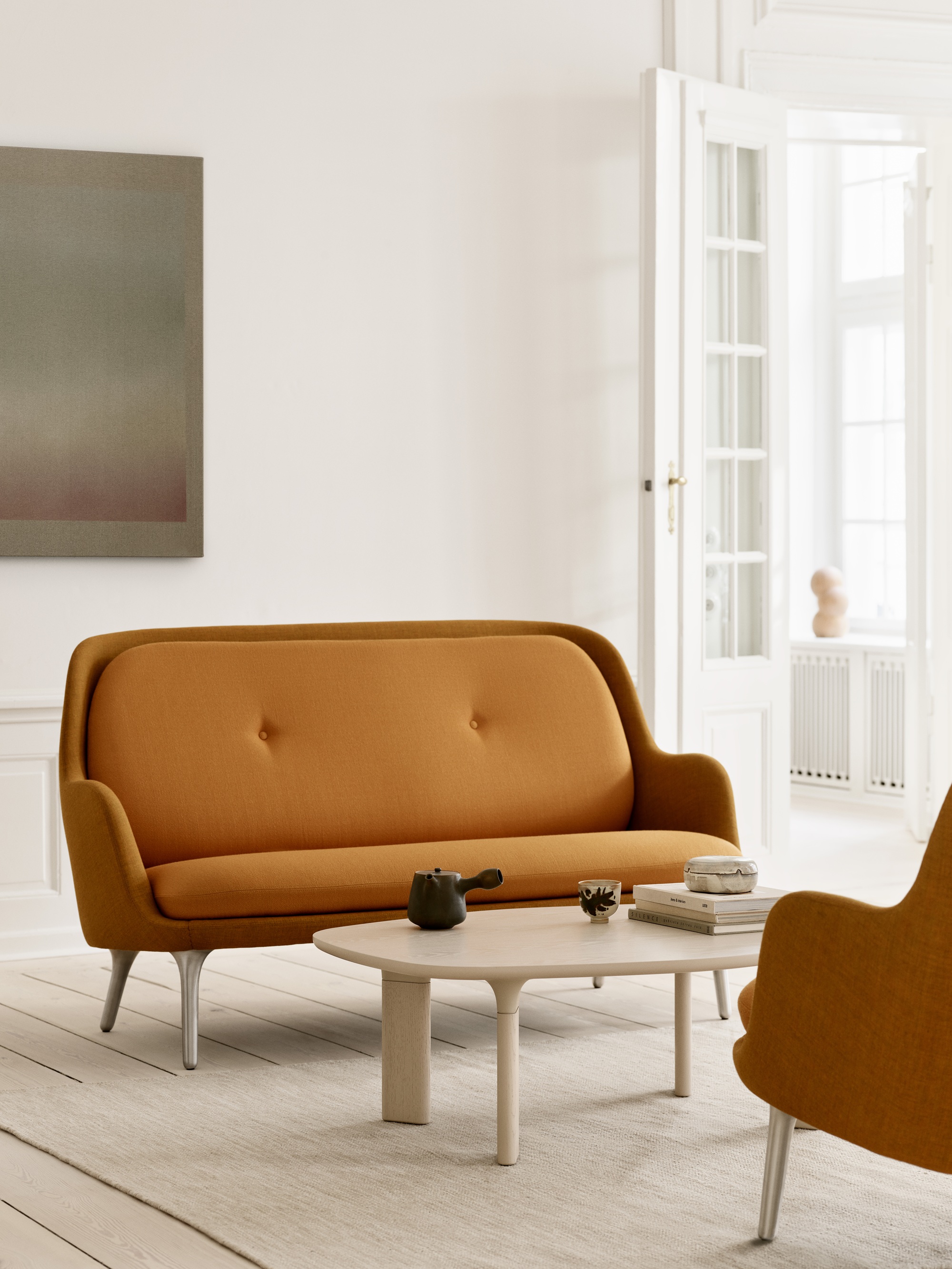 a scandi modern sofa in a caramel color in a white room