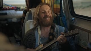 Martin Moon playing guitar in van in Venom: The Last Dance