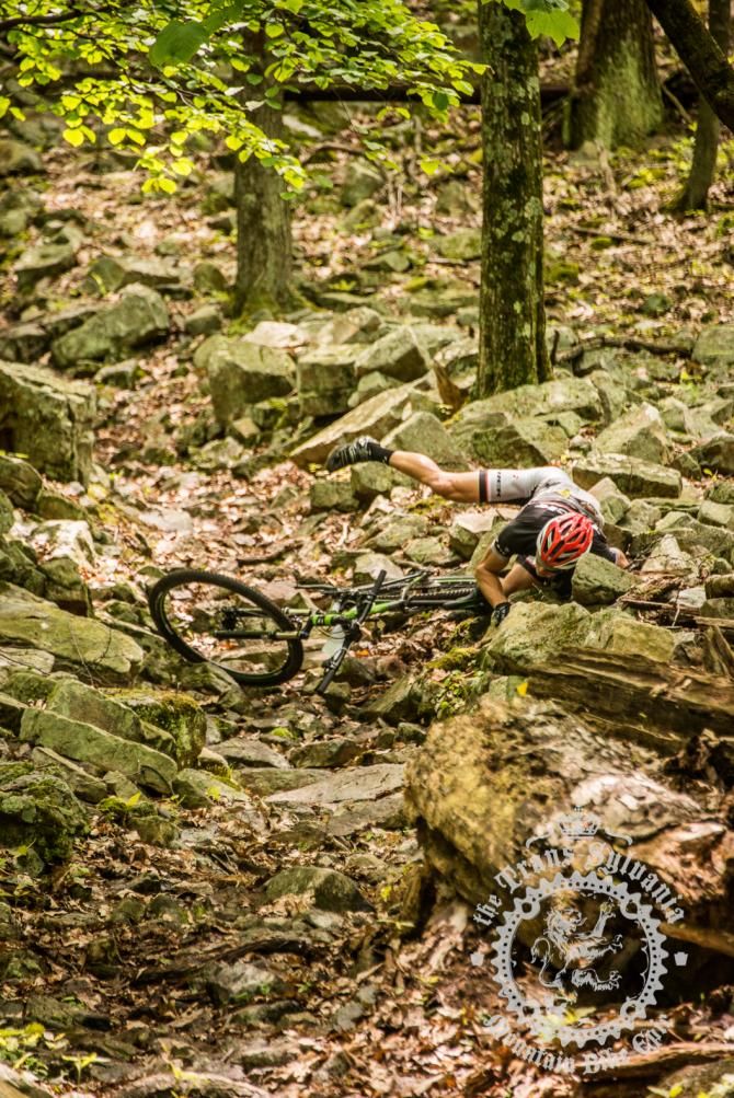 A rider falls on the rocky trailbed of Wildcat Gap Trail.