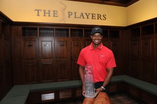 Tiger Woods holding up the Players Championship trophy inside the locker room at TPC Sawgrass in 2013