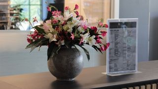 A reception area with flowers and a sign on the counter.