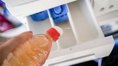 Open the door of white washing machine with a metal drum