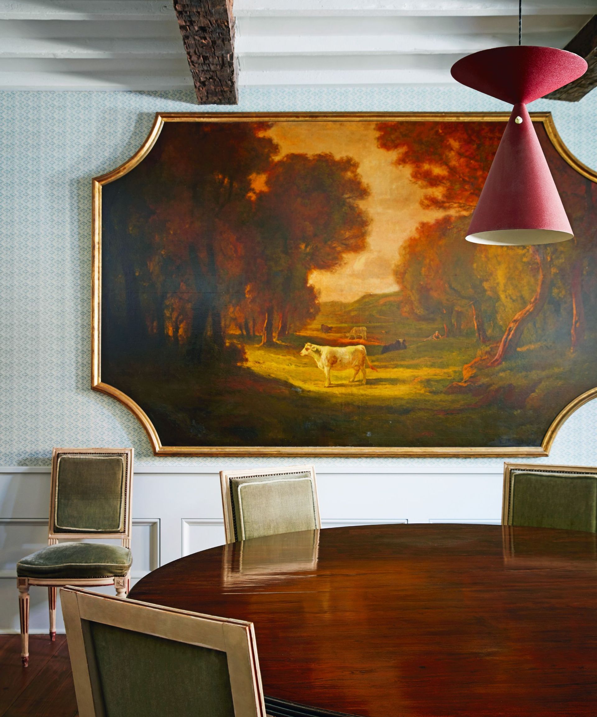 Cow picture, red light, green chair, wooden round table