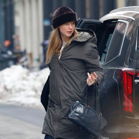 Jennifer lawrence wears a brown fur hat and a green puffer jacket.
