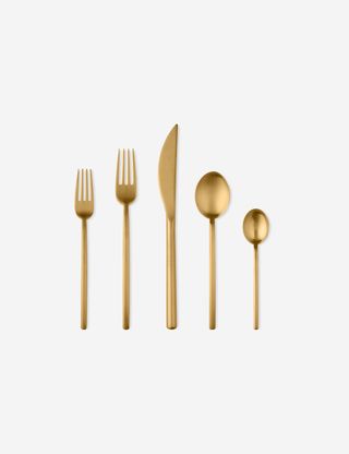 five pieces of gold cutlery laying flat