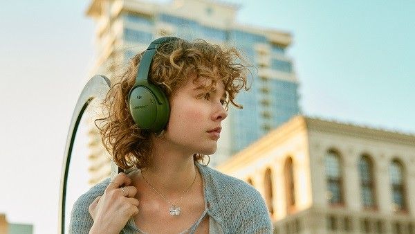 Person wearing Bose Quietcomfort headphones on city rooftop