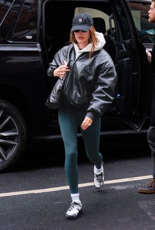 Hailey Bieber is seen on February 3, 2025 in New York City wearing teal alo airlift leggings and a leather bomber jacket