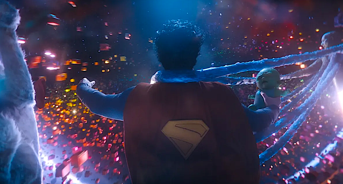 A caped superhero holding a green alien baby