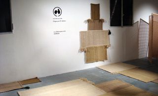 A collection of brown carpets displayed on the floor and the wall.