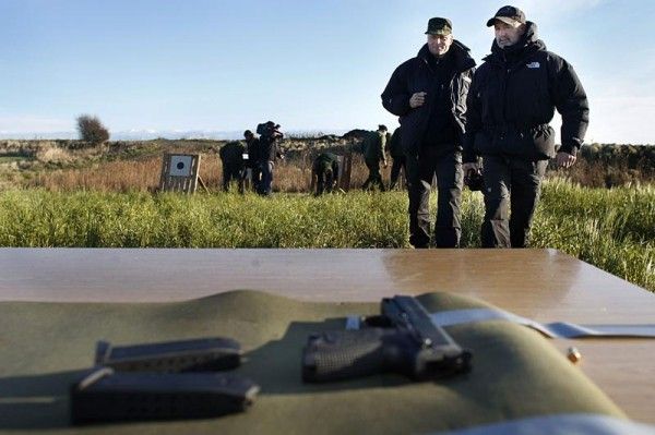 Bjarne Riis and team trainer BS Christiansen approach guns to be used in training.