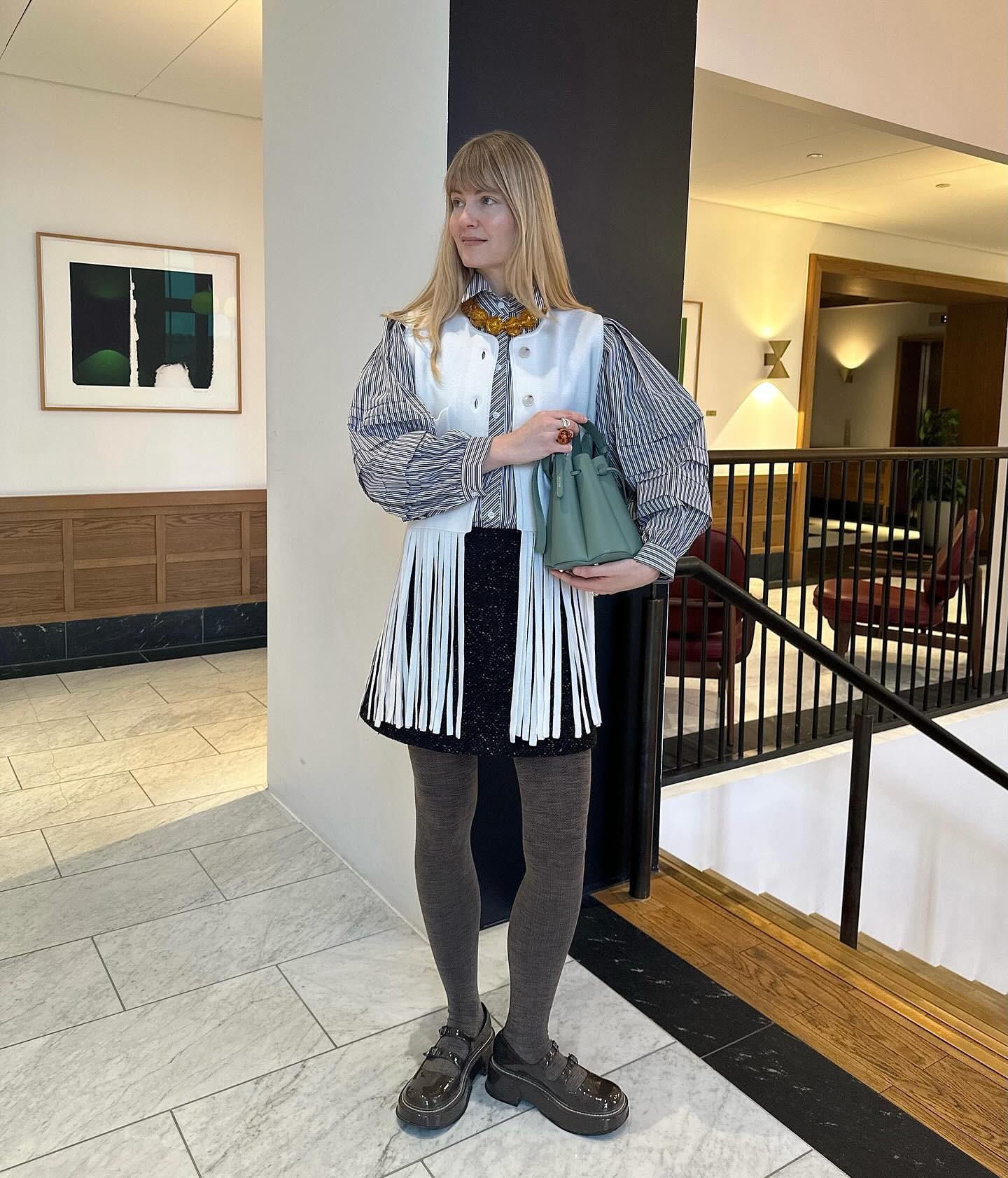 Influencer @annejohannsen wears grey tights with a fringed jacket and gingham blouse.