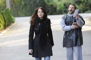 jennifer lawrence walks away while bradley cooper wearing a trash bag and sweats chases her in a silver linings playbook