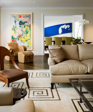 White rug, brown chair, cream walls, wooden floor