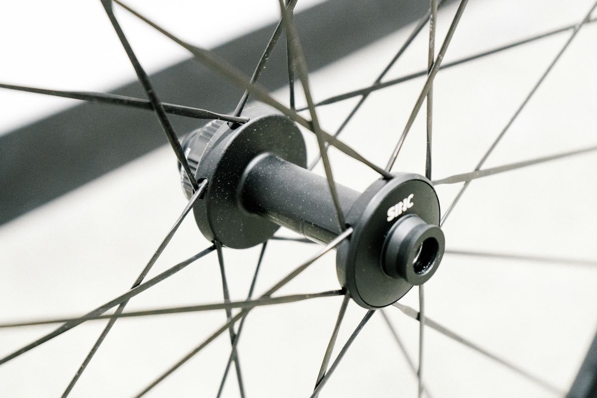 An aero road wheel stands against a white wall