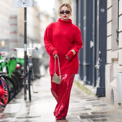 Merve Gorgotz wears sunglasses, a red oversized turtleneck pullover, a golden Rabanne metallic bag, red shiny glitter flowing lustrous skirt, pointed shoes, outside Georges Hobeika, during the Haute Couture Spring/Summer 2024 as part of Paris Fashion Week on January 22, 2024 in Paris, France. (Photo by Edward Berthelot/Getty Images)