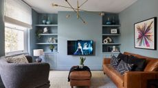 living room with blue wall tv sof sets with cushions and white window