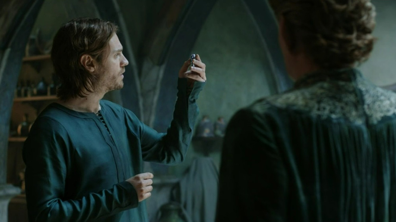 Halbrand sostiene el trozo de mithril hacia la luz mientras Celebrimbor observa en el episodio 8 de The Rings of Power.