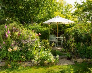 cream garden umbrella with shrubs and lawn