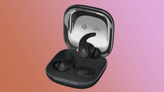 Beats Fit Pro Alo Yoga earbuds in black colorway with case against orange-pink gradient background