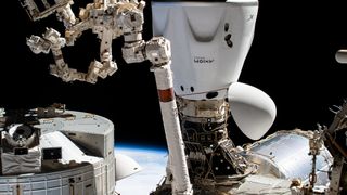 canadarm2 robotic arm in front of spacex spacecraft on international space station