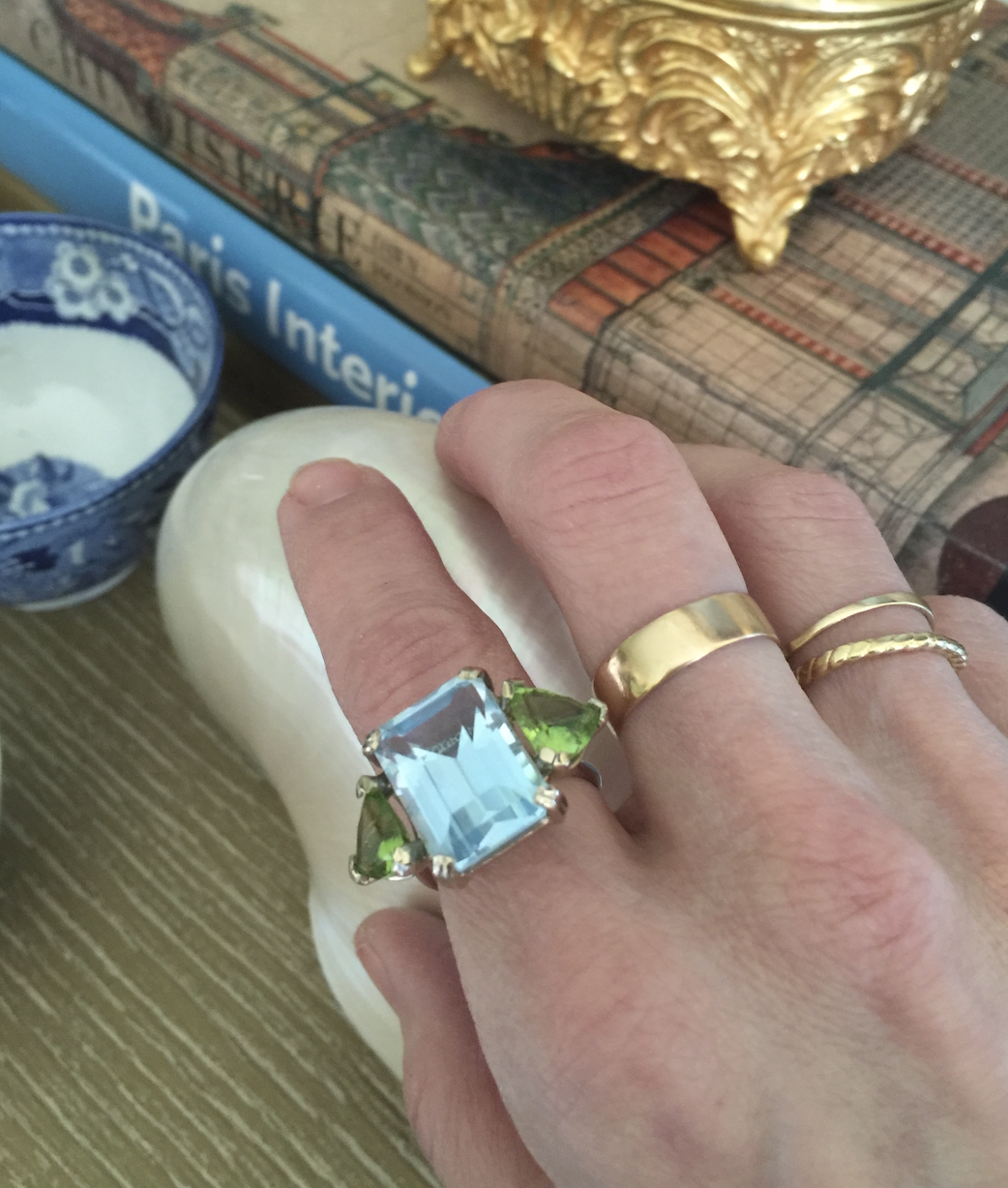 a close-up image of Larissa Mills wearing a stack of silver and gold rings