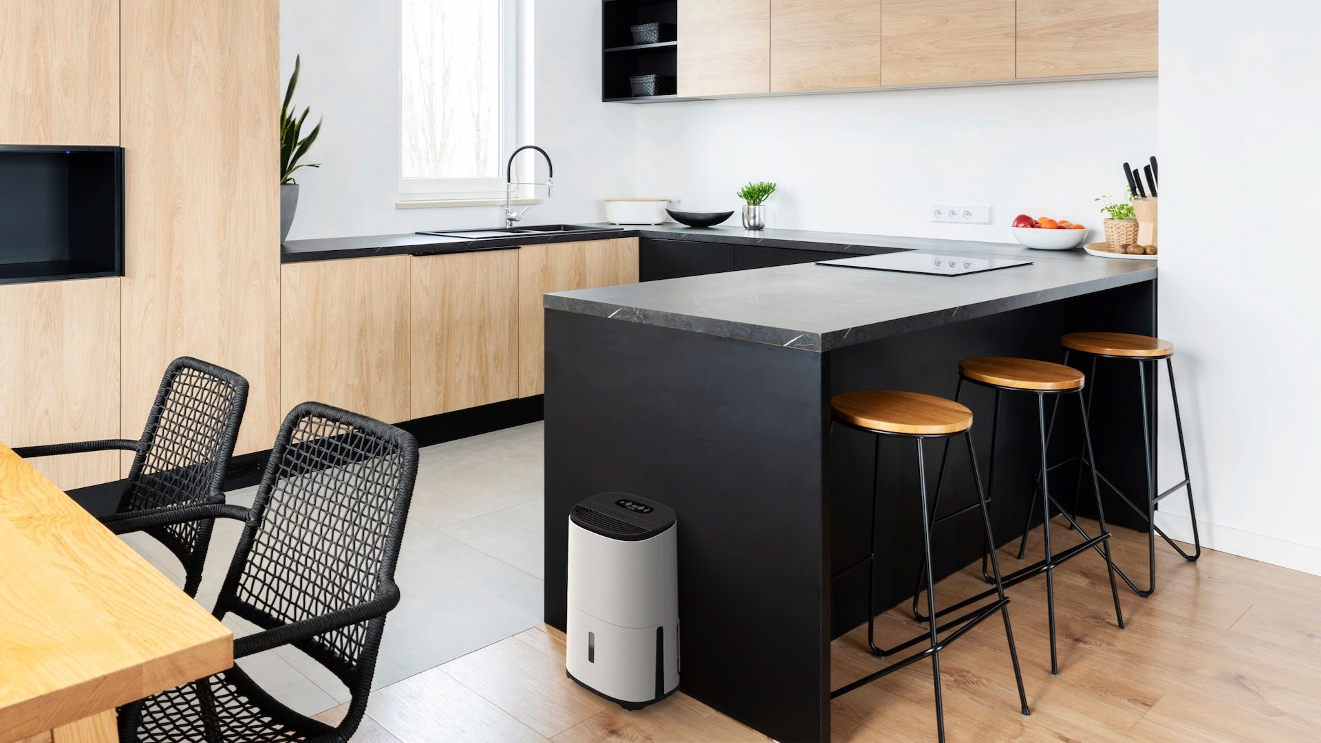 Dehumidifier in kitchen next to breakfast bar and stools