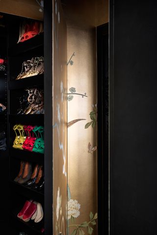 Small walk in closet with gold wallpaper