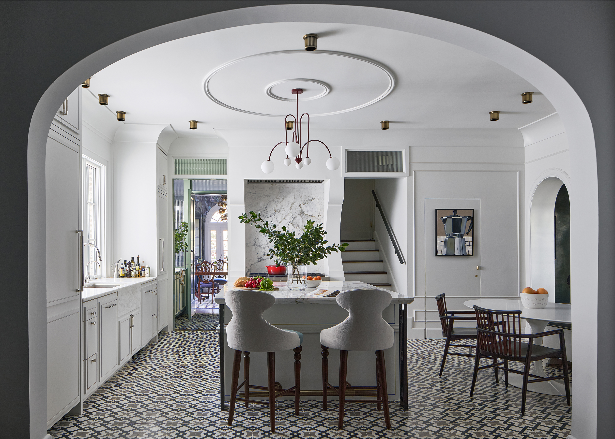 A kitchen with an archway, with an all-white design scheme
