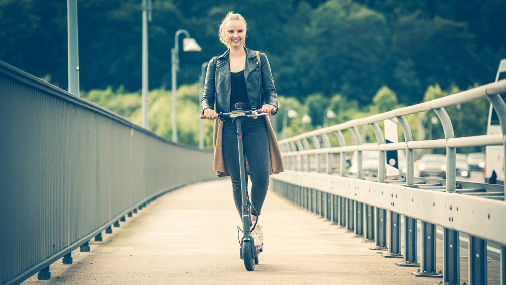 Woman on a scooter on a wooden bridge