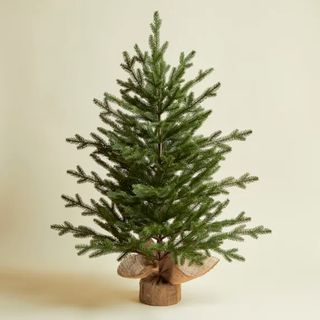 A small 3ft artificial Christmas tree with burlap sack from Dunelm